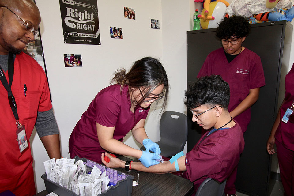 Phlebotomy lab-CTC Students work on their phlebotomy skills as instructor watches on